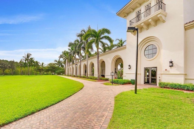 view of property's community featuring a lawn and decorative driveway