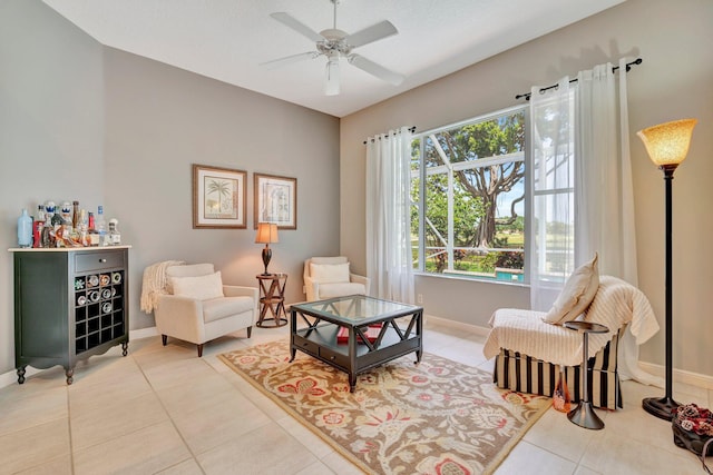 sitting room featuring baseboards, tile patterned floors, and ceiling fan