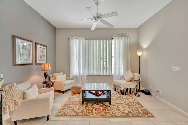 tiled living area featuring baseboards and a ceiling fan