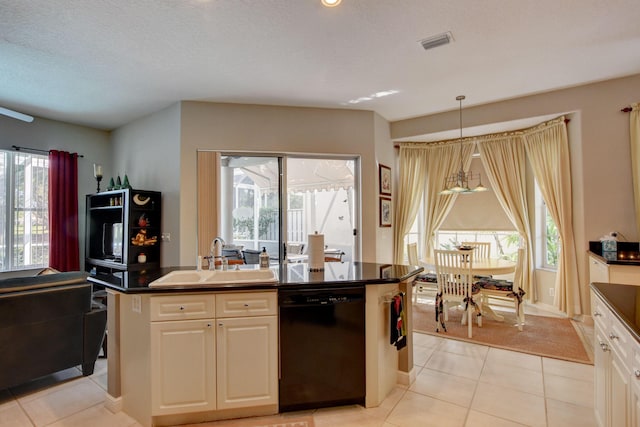 kitchen with a sink, a center island with sink, dark countertops, and dishwasher