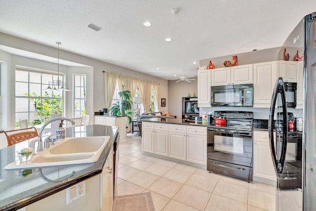 kitchen with black appliances, dark countertops, white cabinets, and a sink