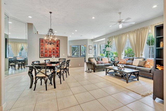 dining area with ceiling fan with notable chandelier, light tile patterned floors, plenty of natural light, and recessed lighting