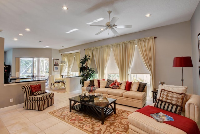 living area featuring baseboards, a ceiling fan, light tile patterned floors, and recessed lighting