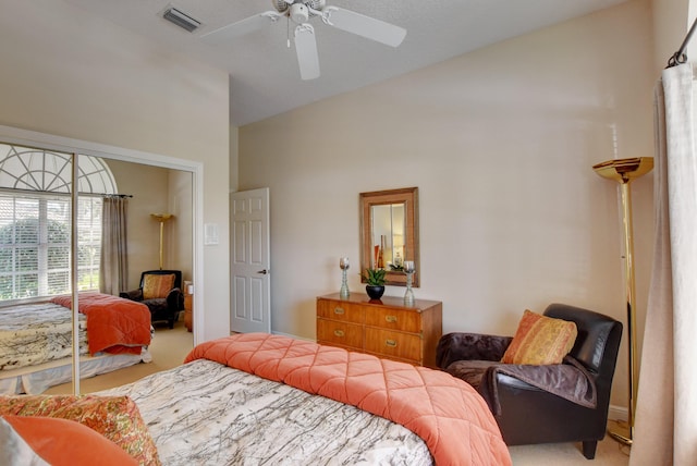 bedroom with a ceiling fan, visible vents, carpet floors, and vaulted ceiling