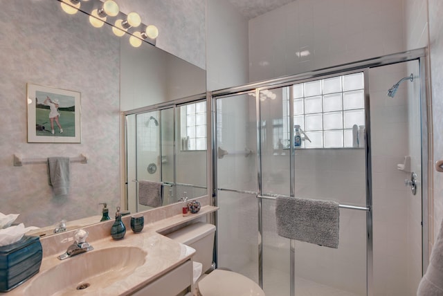 bathroom featuring vanity, toilet, and a stall shower