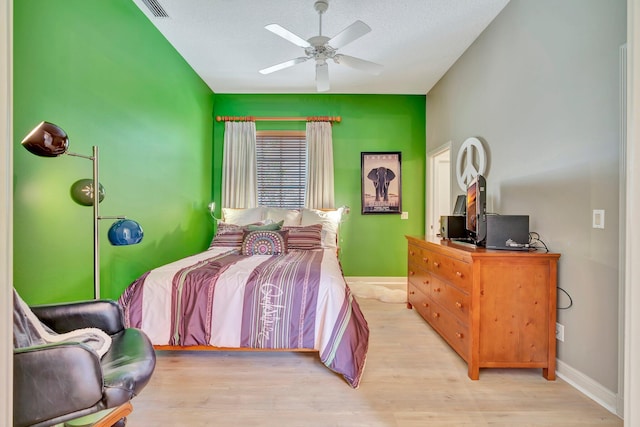 bedroom with ceiling fan, baseboards, and wood finished floors