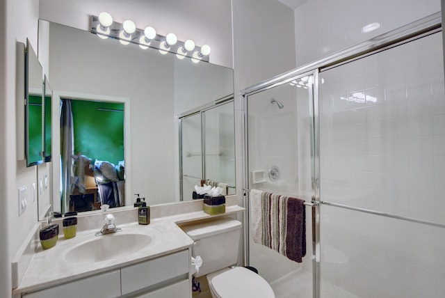 bathroom with a shower stall, vanity, and toilet