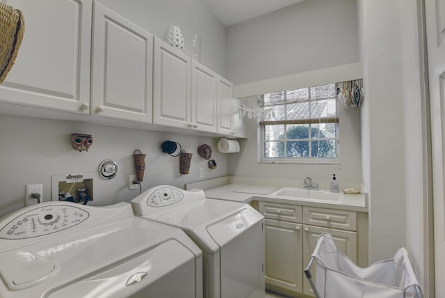 washroom featuring a sink, washing machine and dryer, and cabinet space