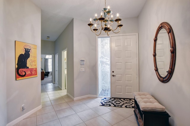 entryway featuring a chandelier, light tile patterned flooring, and baseboards