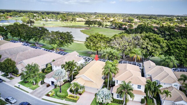 drone / aerial view featuring golf course view, a water view, and a residential view