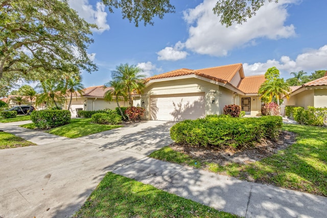 2795 Hawthorne Ln, West Palm Beach, FL 33409 - view of front of home with a tiled roof, stucco siding, driveway, an attached garage, and a front yard