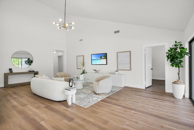 2795 Hawthorne Ln, West Palm Beach, FL 33409 - living area featuring high vaulted ceiling, light wood-style flooring, a chandelier, and baseboards