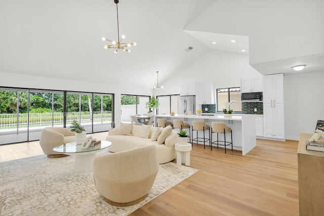 2795 Hawthorne Ln, West Palm Beach, FL 33409 - living area featuring high vaulted ceiling, a chandelier, light wood-style floors, and recessed lighting