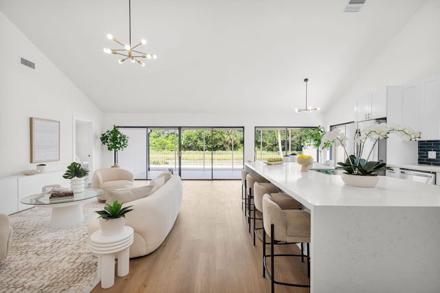 2795 Hawthorne Ln, West Palm Beach, FL 33409 - living area featuring a chandelier, high vaulted ceiling, and light wood-style flooring