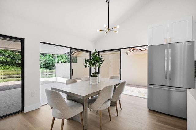 2795 Hawthorne Ln, West Palm Beach, FL 33409 - dining area featuring light wood finished floors, a chandelier, and high vaulted ceiling