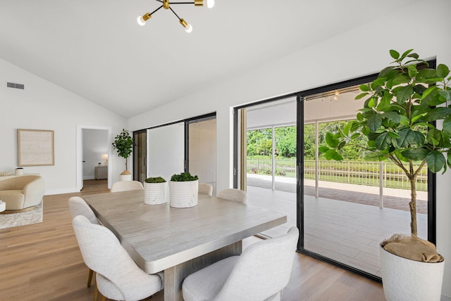 2795 Hawthorne Ln, West Palm Beach, FL 33409 - dining area with a chandelier, light wood-style floors, high vaulted ceiling, and baseboards