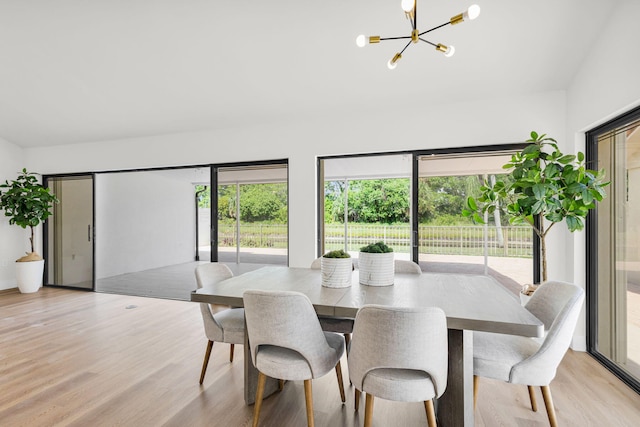 2795 Hawthorne Ln, West Palm Beach, FL 33409 - dining room with a chandelier, light wood-style flooring, and vaulted ceiling