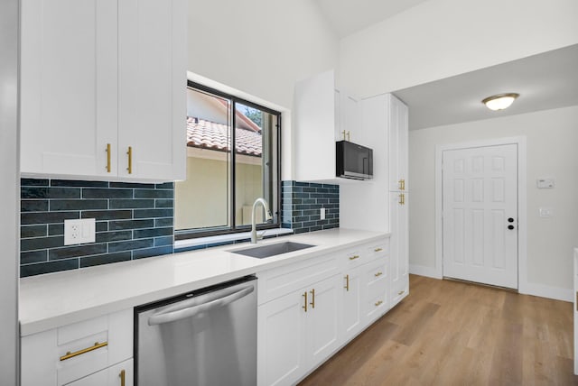 2795 Hawthorne Ln, West Palm Beach, FL 33409 - kitchen with dishwasher, a sink, black microwave, light wood-style floors, and white cabinetry