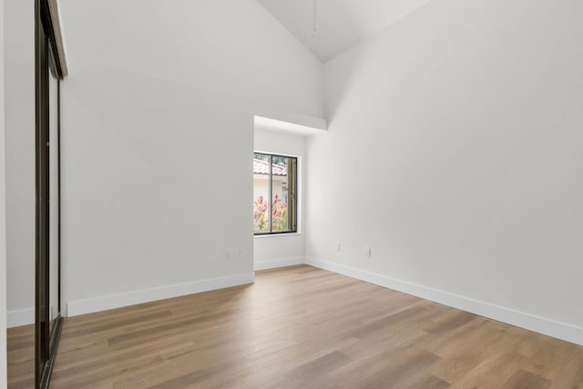 2795 Hawthorne Ln, West Palm Beach, FL 33409 - empty room featuring high vaulted ceiling, wood finished floors, and baseboards