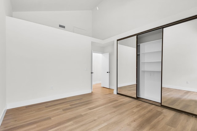 2795 Hawthorne Ln, West Palm Beach, FL 33409 - unfurnished bedroom with high vaulted ceiling, light wood-type flooring, baseboards, and a closet