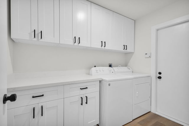 2795 Hawthorne Ln, West Palm Beach, FL 33409 - laundry area featuring cabinet space, separate washer and dryer, and light wood-style floors