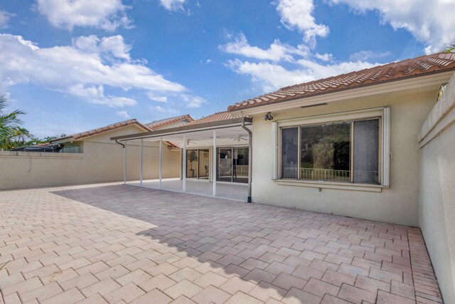 2795 Hawthorne Ln, West Palm Beach, FL 33409 - back of house featuring a patio, stucco siding, a tile roof, and a sunroom