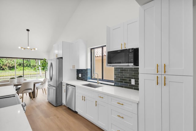 2795 Hawthorne Ln, West Palm Beach, FL 33409 - kitchen with stainless steel appliances, a sink, decorative backsplash, a chandelier, and light countertops