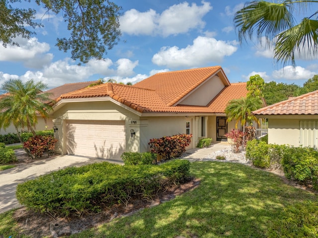 2795 Hawthorne Ln, West Palm Beach, FL 33409 - mediterranean / spanish-style house with an attached garage, a tiled roof, a front yard, stucco siding, and driveway