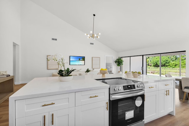 2795 Hawthorne Ln, West Palm Beach, FL 33409 - kitchen featuring electric range, high vaulted ceiling, a chandelier, white cabinets, and light wood-type flooring