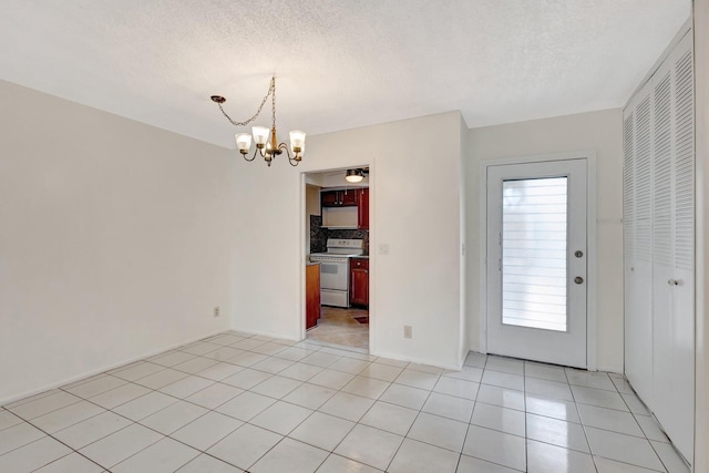 unfurnished dining area featuring a textured ceiling, light tile patterned flooring, and a chandelier