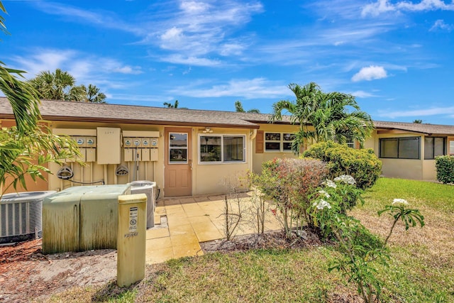 rear view of property with central AC unit and stucco siding