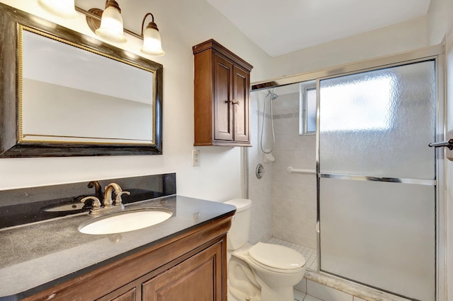 bathroom with vanity, a shower stall, and toilet