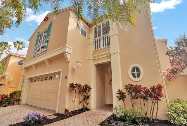 7 Via Tivoli, Palm Beach Gardens, FL 33418 - view of front of home featuring a garage, stucco siding, a balcony, and driveway