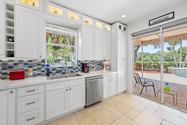 4474 Thornwood Cir, Palm Beach Gardens, FL 33418 - kitchen with stainless steel dishwasher, a sink, decorative backsplash, light countertops, and white cabinets
