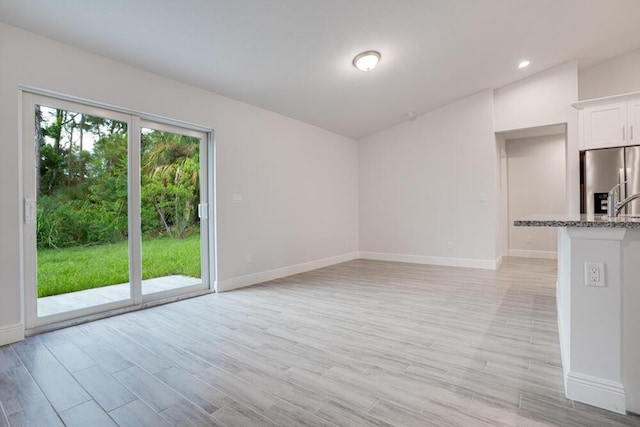 1222 SW Albenga Ave, Port Saint Lucie, FL 34953 - unfurnished living room with recessed lighting, baseboards, and light wood-type flooring