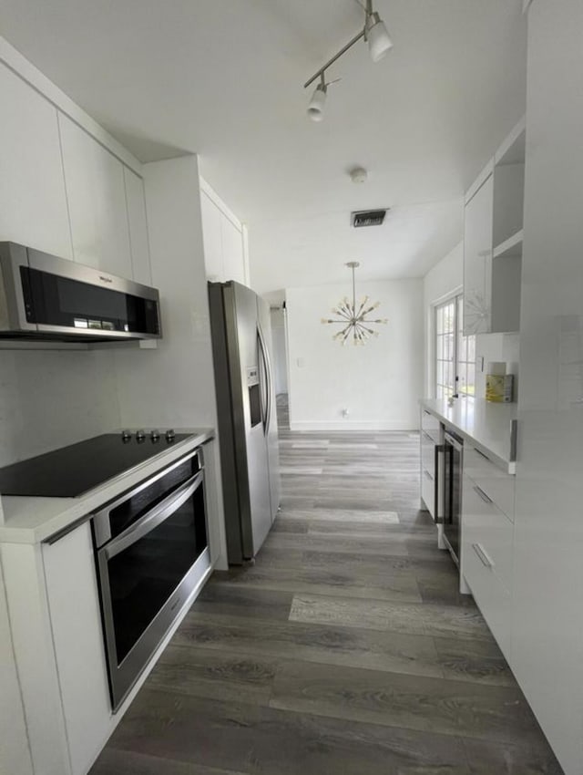 kitchen featuring beverage cooler, stainless steel appliances, white cabinetry, and modern cabinets