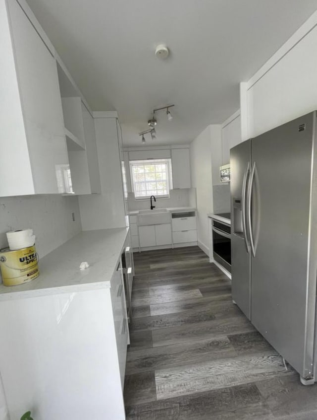 kitchen featuring open shelves, a sink, light countertops, stainless steel appliances, and white cabinetry