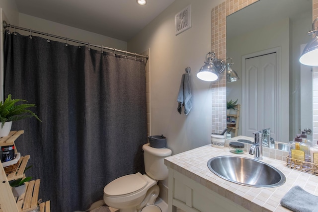 bathroom featuring vanity, toilet, curtained shower, and visible vents