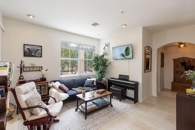 living area with visible vents, arched walkways, baseboards, and recessed lighting