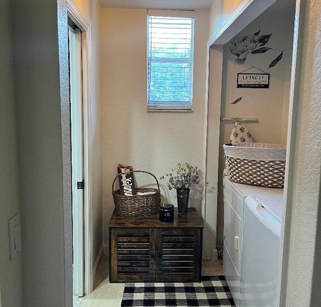 laundry area with laundry area, a textured wall, and washing machine and dryer