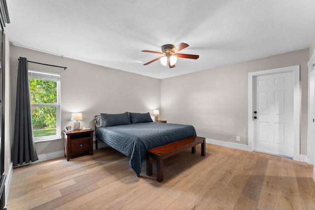 bedroom with light wood-type flooring, a ceiling fan, and baseboards
