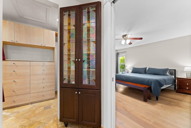 bedroom with a ceiling fan and attic access