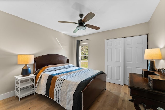 bedroom with baseboards, ceiling fan, a closet, and wood finished floors