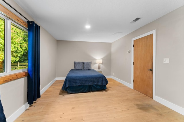bedroom featuring baseboards, visible vents, and light wood-style flooring