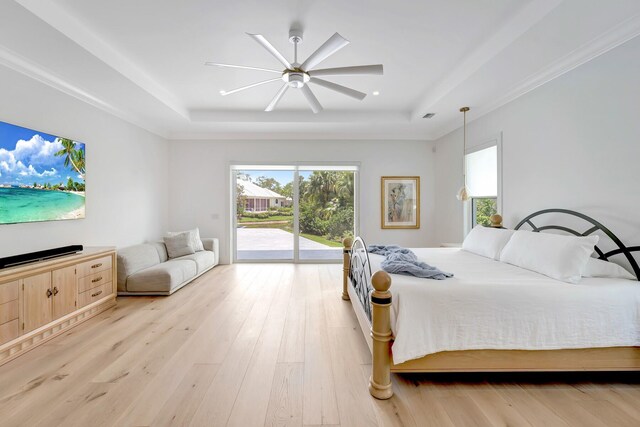 bedroom featuring a raised ceiling, visible vents, light wood-style flooring, and access to exterior