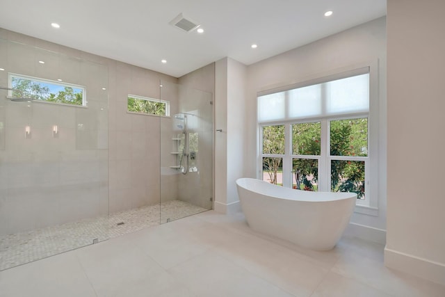 bathroom featuring a walk in shower, tile patterned flooring, recessed lighting, baseboards, and a soaking tub