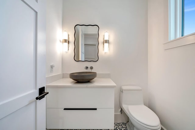 half bathroom featuring vanity and toilet