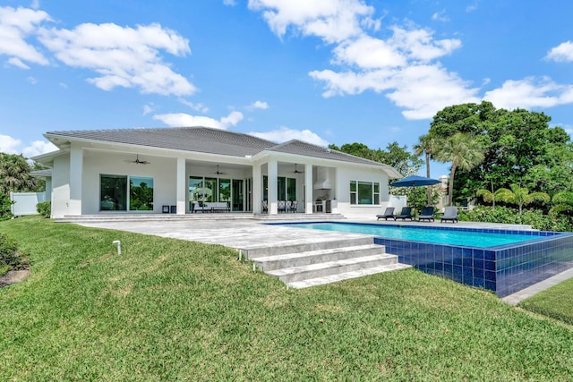 rear view of property featuring a lawn, ceiling fan, and a patio area