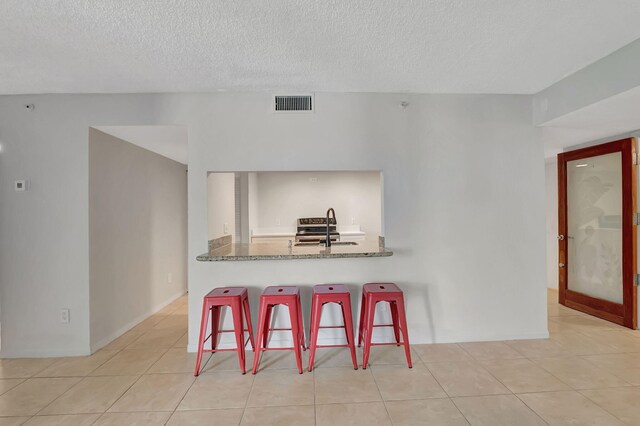 dining room featuring a textured ceiling, tile patterned floors, and visible vents