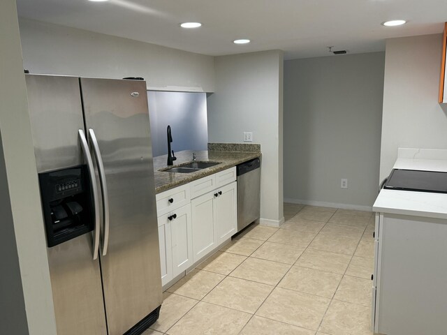 kitchen featuring a sink, white cabinetry, dark stone countertops, and stainless steel appliances